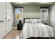 Comfortable bedroom with hardwood floors, two windows and a cozy bed with gray striped bedding at 3453 Navajo St, Denver, CO 80211