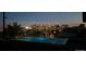 Nighttime view of a rooftop pool with illuminated city skyline in the background at 3453 Navajo St, Denver, CO 80211