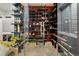 A climate-controlled wine cellar features artistic shelving, display lighting, and glass door at 3453 Navajo St, Denver, CO 80211