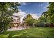 Spacious backyard showcasing a well-maintained lawn, deck, patio, and mature trees at 10154 Fairgate Way, Highlands Ranch, CO 80126