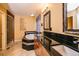 Bathroom featuring a large bathtub and dual vanity with black countertops at 10154 Fairgate Way, Highlands Ranch, CO 80126