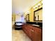 Bathroom featuring dual sinks, wooden cabinets, granite countertop, and stylish tiled backsplash at 10154 Fairgate Way, Highlands Ranch, CO 80126