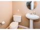 Powder room with pedestal sink and toilet at 10154 Fairgate Way, Highlands Ranch, CO 80126