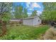 Spacious backyard featuring a detached garage, green lawn, and mature trees at 360 S Ogden St, Denver, CO 80209