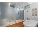 Modern bathroom featuring a glass-enclosed shower, soaking tub, and natural light from the window at 360 S Ogden St, Denver, CO 80209