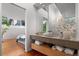 Bright bathroom featuring a concrete sink, wood floors, and an open doorway to the bedroom at 360 S Ogden St, Denver, CO 80209