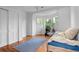 Sunlit bedroom with wood floors, a comfortable bed, and a view of the outdoors through the window at 360 S Ogden St, Denver, CO 80209