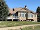 Rear view of house featuring a deck, large windows, stone accents, and a beautifully maintained lawn at 6772 Vista Lodge Loop, Castle Pines, CO 80108