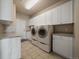 Laundry room featuring cabinets, tile flooring, and modern washer and dryer at 6772 Vista Lodge Loop, Castle Pines, CO 80108