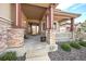 Covered front porch with stone columns, decorative railing, and meticulously maintained landscaping at 6772 Vista Lodge Loop, Castle Pines, CO 80108