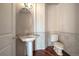 Powder room with pedestal sink, oval mirror, and tile accent wall at 6772 Vista Lodge Loop, Castle Pines, CO 80108