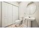 Bathroom features a pedestal sink, toilet, and storage closet at 19658 E Vassar Dr, Aurora, CO 80013