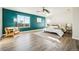 Bright bedroom with a feature wall, ceiling fan, and natural light from a large window at 19658 E Vassar Dr, Aurora, CO 80013