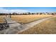 Wide view of community park featuring a concrete walkway that runs along side a large field of dry grass at 19658 E Vassar Dr, Aurora, CO 80013