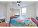 Bedroom featuring a ceiling fan, closet with mirrored doors, a window, and carpeted flooring at 14050 W 8Th Ave, Golden, CO 80401