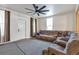 Cozy living room with plush gray sectional, large ceiling fan, and natural light from a large window at 14050 W 8Th Ave, Golden, CO 80401