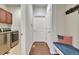Welcoming hallway includes a bench with an American flag pillow and a laundry room on the left at 14916 E Crestridge Pl, Centennial, CO 80015