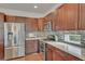 Modern kitchen featuring stainless steel appliances, dark wood cabinets, and stylish backsplash at 14916 E Crestridge Pl, Centennial, CO 80015
