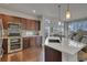 Modern kitchen featuring dark wood cabinets, stainless steel appliances, and a large island with a white countertop at 14916 E Crestridge Pl, Centennial, CO 80015