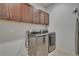Well-organized laundry room features modern washer and dryer units and storage cabinets above at 14916 E Crestridge Pl, Centennial, CO 80015