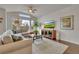 Cozy living room with a sectional sofa, large windows, a ceiling fan, and elegant decor at 14916 E Crestridge Pl, Centennial, CO 80015