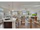 Open-concept living room and kitchen with hardwood floors, a vaulted ceiling, and large windows providing natural light at 14916 E Crestridge Pl, Centennial, CO 80015