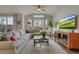 Bright living room featuring a large sectional sofa, expansive windows, and a contemporary entertainment center at 14916 E Crestridge Pl, Centennial, CO 80015