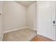 Small bedroom with tan carpet and base molding with white trim and a view of the door at 307 Inverness S Way # 307, Englewood, CO 80112