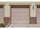Attached garage door features red brick detail and tan trim at 307 Inverness S Way # 307, Englewood, CO 80112
