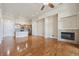 Open-concept living room featuring a modern fireplace, hardwood floors, and a kitchen with counter seating at 307 Inverness S Way # 307, Englewood, CO 80112