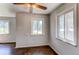This bedroom features light grey walls, three windows and beautiful wood floors at 3311 S Eudora St, Denver, CO 80222