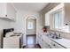 Galley kitchen features laminate floor, white cabinets and updated countertops at 3311 S Eudora St, Denver, CO 80222