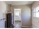 Utility room featuring a water heater and access to the kitchen at 3311 S Eudora St, Denver, CO 80222