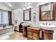 Elegant bathroom with standalone tub and double vanity sinks with dark wood trim at 36920 Forest Trl, Elizabeth, CO 80107