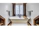 Clawfoot bathtub with elegant fixtures and shelf and towel storage nearby at 36920 Forest Trl, Elizabeth, CO 80107