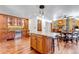 Open-concept kitchen and dining area with custom island, cabinetry, and hardwood floors at 36920 Forest Trl, Elizabeth, CO 80107