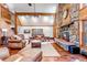 Spacious living room featuring stone fireplace, wood beam ceilings, and lots of natural light at 36920 Forest Trl, Elizabeth, CO 80107