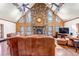 Spacious living room with a stone fireplace, beamed ceilings, and hardwood floors, creating a cozy atmosphere at 36920 Forest Trl, Elizabeth, CO 80107