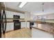 Kitchen with white cabinets, black appliances, and a breakfast bar at 10219 Vine Ct, Thornton, CO 80229