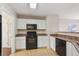 Kitchen with white cabinets, black appliances, and a breakfast bar at 10219 Vine Ct, Thornton, CO 80229