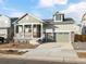 Two-story house with a green exterior, a two-car garage, and a front porch at 17355 E 91St Pl, Commerce City, CO 80022