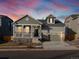 Two-story house with a green exterior, a two-car garage, and a front porch at 17355 E 91St Pl, Commerce City, CO 80022