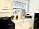 Bright kitchen features white cabinets, tiled countertops, and modern appliances at 215 E 11Th Ave # A11, Denver, CO 80203