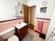 Clean bathroom with pink tile, a vanity, and a toilet at 3001 Pontiac St, Denver, CO 80207