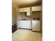Kitchen area features white cabinets and appliances, alongside a washing machine, providing essential amenities at 804 S 1St Ave, Brighton, CO 80601
