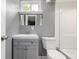 Bathroom featuring gray vanity, a mirror, a toilet, and a shower at 5635 Nebraska Way, Denver, CO 80224