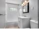 Bright bathroom with white vanity, bath and shower combo and vanity lighting at 5635 Nebraska Way, Denver, CO 80224