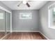 Bedroom featuring a mirrored closet, gray walls, wood floors, and a window at 5635 Nebraska Way, Denver, CO 80224