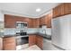 Updated kitchen featuring stainless steel appliances, wood cabinetry, and sleek black countertops at 5635 Nebraska Way, Denver, CO 80224