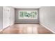 Bright living room featuring hardwood floors, a large window, and a modern front door at 5635 Nebraska Way, Denver, CO 80224